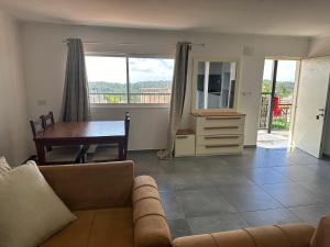 a living room with a couch and a table and a desk at carmel cabins suite nu 9 in Yājur +10 photos
