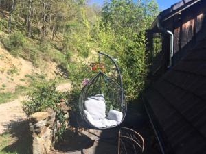a swing with white pillows on it next to a hill at La Bernadole - Chambres d'Hôtes in Aleu
