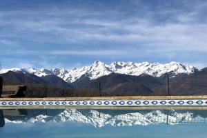 a reflection of snow capped mountains in a body of water at La Bernadole - Chambres d'Hôtes in Aleu