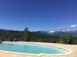 a swimming pool with mountains in the background at La Bernadole - Chambres d'Hôtes in Aleu