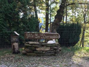 a white cat sitting on top of a sign at La Bernadole - Chambres d'Hôtes in Aleu +11 photos
