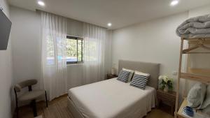 a bedroom with a bed and a window at Refúgio do Tâmega in Penafiel