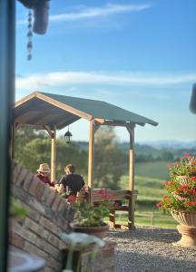 two people sitting at a table under a pavilion at Wine Resort Colsereno in Montalcino +69 photos
