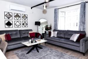 a living room with two couches and a coffee table at Pasture Side House in Clayton