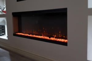 a fireplace with a fire inside of it at Pasture Side House in Clayton +36 photos