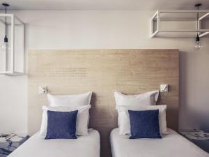 two beds sitting next to each other in a room at Mercure Nancy Centre Gare in Nancy