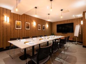 a conference room with a long table and chairs at Mercure Paris Ouest Saint Germain in Saint-Germain-en-Laye