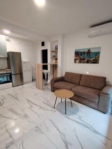 a living room with a couch and a table on a marble floor at Shark Herceg Novi in Meljine