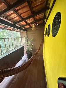 a hammock in a room with a balcony at Hari Eco Pousada in Brumadinho