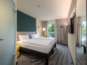 a hotel room with a large bed in a room at ibis Leipzig City in Leipzig +55 photos