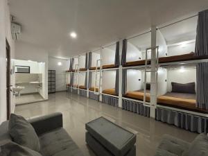 a room with several bunk beds and a couch at Jimbaran Hostel Bali in Jimbaran