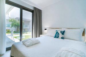 a bedroom with a white bed with a large window at Thassos OLIVIA RESORT in Potos +79 photos