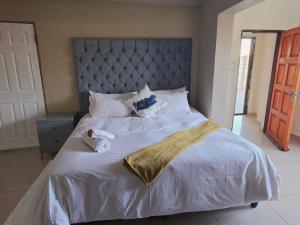 a bed with white sheets and towels on it at Mafjoint6 in eMalahleni