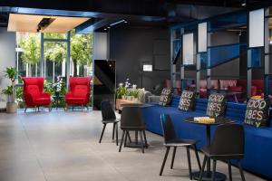 a waiting room with red chairs and tables at Aloft by Marriott Miami - Brickell in Miami