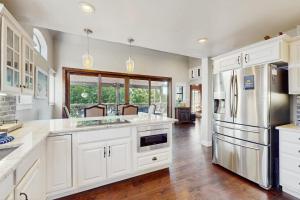 a kitchen with white cabinets and a refrigerator at Opulent Waterfront Home with Dock, Firepit & Stunning River View in Burnet