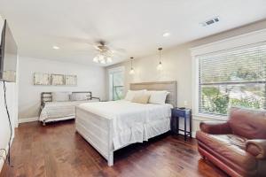 a bedroom with a white bed and a couch at Opulent Waterfront Home with Dock, Firepit & Stunning River View in Burnet