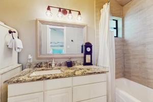a bathroom with a sink and a mirror and a shower at Opulent Waterfront Home with Dock, Firepit & Stunning River View in Burnet +18 photos