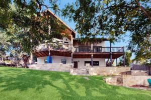 a large house with a balcony and a yard at Opulent Waterfront Home with Dock, Firepit & Stunning River View in Burnet