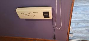 a box is hanging on a purple wall at Cabañas Caprumadp in Quintero