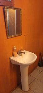 a bathroom with a white sink and a mirror at Cabañas Caprumadp in Quintero +8 photos