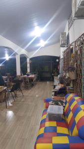 a room with colorful couches in a room with tables at Melizas Garden Pousada em Foz do Iguaçu in Foz do Iguaçu