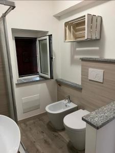 a white bathroom with a toilet and a sink at Cà Dal Vindu in Biella