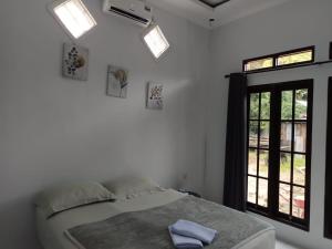 a bedroom with a bed with a window at Raja Ampat Sandy Guest House in Saonek
