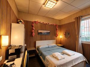 a bedroom with a bed with two towels on it at BED & BREAKFAST SAKURA in Milan