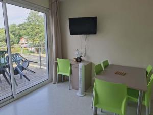 a dining room with a table and chairs and a television at cottage poussin 12 picine lave linge in Chaveignes