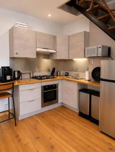 a kitchen with stainless steel appliances and wooden floors at Suite Le Mans 70 in Pusey +28 photos