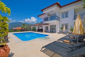 a villa with a swimming pool and patio furniture at Villa Ahad in Fethiye