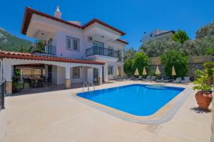 a villa with a swimming pool in front of a house at Villa Ahad in Fethiye