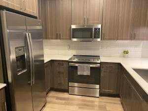 a kitchen with stainless steel appliances and wooden cabinets at Coastal Life at Aqua in Bradenton