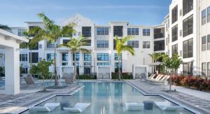a swimming pool with chairs and a building at Coastal Life at Aqua in Bradenton