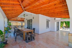 a patio with a wooden ceiling and a table and chairs at Villa Ahad in Fethiye