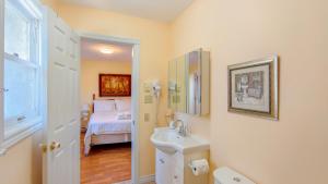 a bathroom with a sink and a bedroom with a bed at Lee's Ocean Peek B & B in Stratford +58 photos