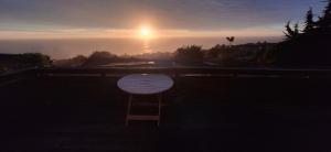 a wooden chair sitting in front of a sunset at Cabañas Caprumadp in Quintero