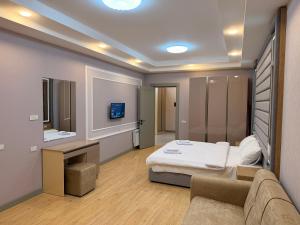 a room with a bed and a couch and a tv at Bea Paradise 113 in Baku