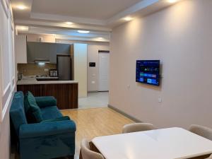 a living room with a couch and a table and a kitchen at Bea Paradise 113 in Baku