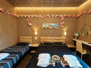 a bedroom with two beds and a table and a desk at BED & BREAKFAST SAKURA in Milan