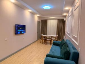 a living room with a blue couch and a table at Bea Paradise 113 in Baku