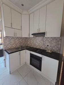 a kitchen with white cabinets and a black stove top oven at Mafjoint10 in eMalahleni