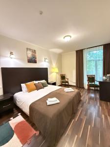 a bedroom with a large bed with two towels on it at Alex Hotel in Odesa