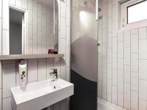 a white bathroom with a sink and a shower at Hôtel ibis Styles Vichy Centre in Vichy +64 photos