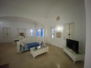 a living room with a couch and a tv at Menzel à Midoun in Al Maqārisah