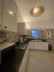 a kitchen with white cabinets and a sink and a window at Menzel à Midoun in Al Maqārisah