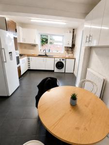 a kitchen with a wooden table and a kitchen with white cabinets at Lindi Property Cosy Double Room in Wyken