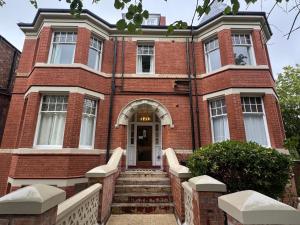 a red brick building with a staircase leading to the front door at Charlie Hotel in London