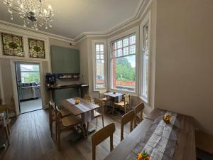 a kitchen with wooden tables and chairs and windows at Charlie Hotel in London