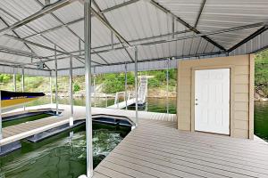 a dock with a door on a boat in the water at Natural Cliffside Oasis with Impressive Views, Gas Fireplace and Dock in Spicewood